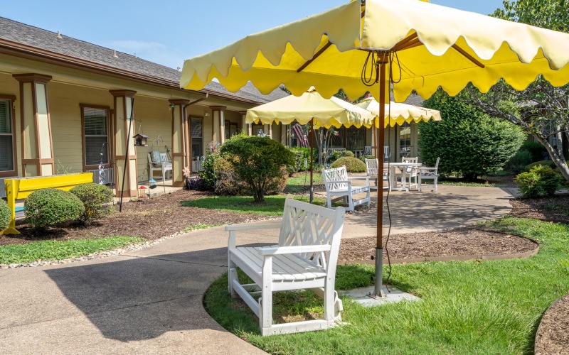 outdoor seating area with a bench under an umbrella