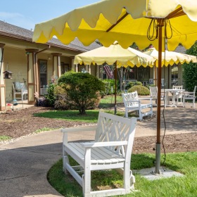 Love where you live outdoor seating area with a bench under an umbrella
