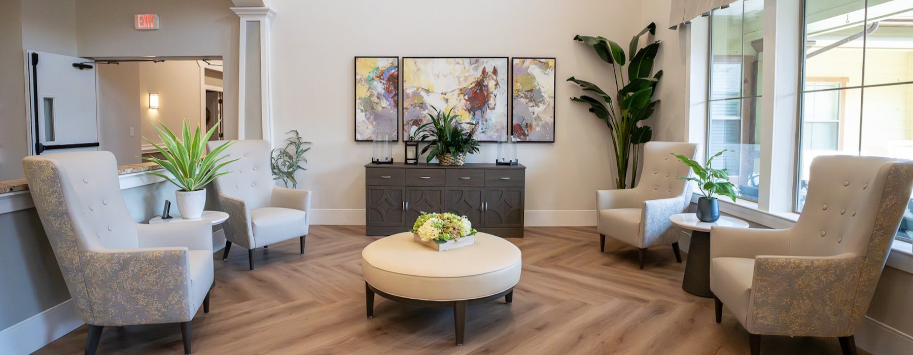 a seating area with chairs and decorations next to a large window