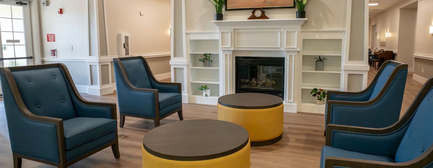 a seating area with blue chairs next to a fireplace