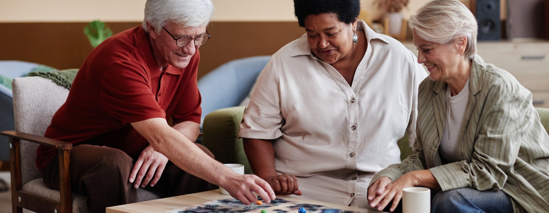 Residents and caregiver solving a puzzle